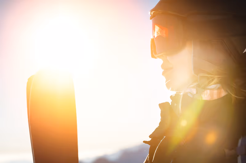 Skieur au coucher du soleil sur les hauteurs d’une station