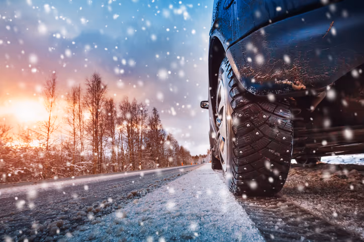 Winter tyres on a snow-covered road to a ski resort