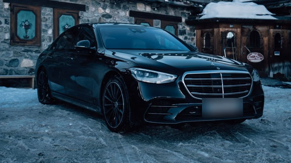 Notre Mercedes Classe S noire devant un chalet alpin, dans la neige